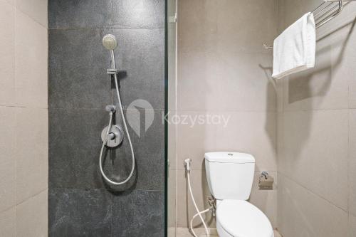 a bathroom with a shower and a toilet in it at Bialy by Kozystay - Alam Sutera in Tangerang