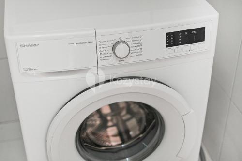 a white washer and dryer in a room at Bialy by Kozystay - Alam Sutera in Tangerang