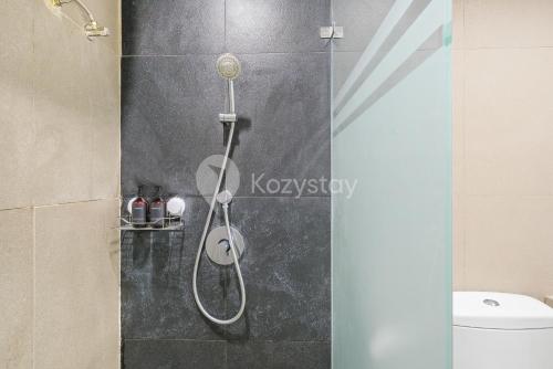 a shower with a shower head in a bathroom at Bialy by Kozystay - Alam Sutera in Tangerang