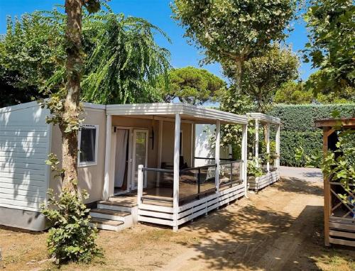 a white tiny house with a porch at Victoria Mobilehome in Union Camping Cavallino in Cavallino-Treporti