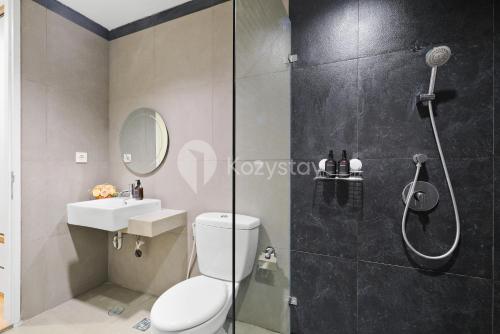 a bathroom with a shower and a toilet and a sink at Bialy by Kozystay - Alam Sutera in Tangerang