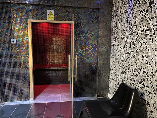 a glass door in a room with a red light at Queens Hotel & Spa in Brighton & Hove