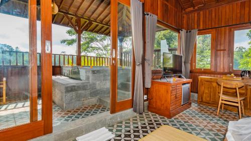 a room with a bathroom with a tub and a television at Magatama Villa by Mahaputra in Gianyar