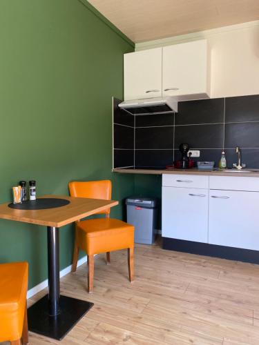 a kitchen with a table and two chairs and a table at Landgoed Leudal in Haelen