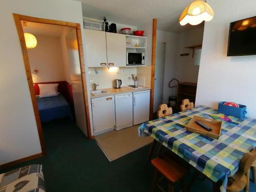 une petite pièce avec une table et une cuisine dans l'établissement Appartement 4 pers · Ski aux pieds · Balcon · Casier à skis · Parking gratuit - FR-1-181-2534, à Aime La Plagne