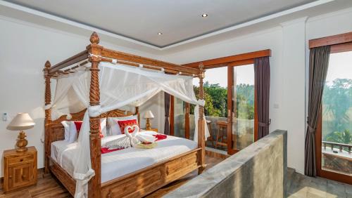 a bedroom with a canopy bed and a balcony at Magatama Villa by Mahaputra in Gianyar