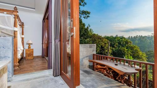 an open door to a balcony with a wooden bench at Magatama Villa by Mahaputra in Gianyar
