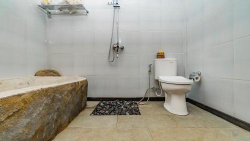 a bathroom with a toilet and a bath tub at Magatama Villa by Mahaputra in Gianyar