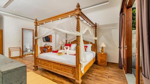 a bedroom with a four poster bed with a canopy at Magatama Villa by Mahaputra in Gianyar