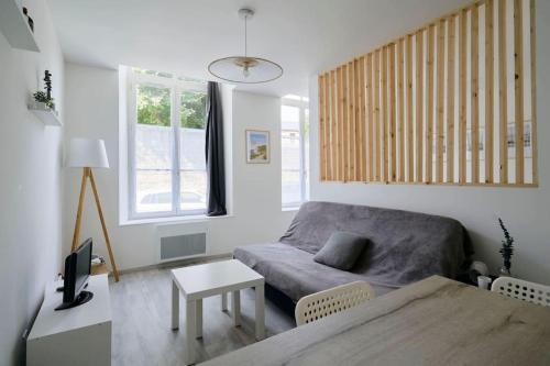 un petit salon avec un canapé et une table dans l'établissement Le Nid Douillet - Appart 2-4P vieux Boulogne, à Boulogne-sur-Mer