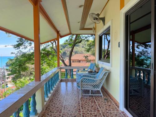 a porch with a table and chairs and the ocean at Sea Dreamer Ao Yon Beach House in Ban Ao Makham