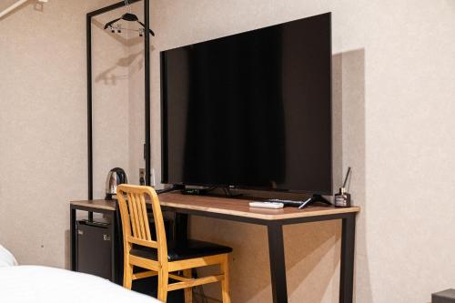 a desk with a television on it in a bedroom at Incheon Airport Hotel Seattle in Incheon