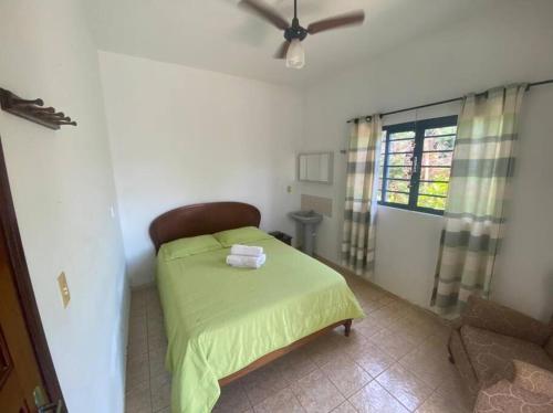 Rancho Lindas Aguas Carmo do Rio Claro في كارمو دو ريو كلارو: غرفة نوم بها سرير ومروحة سقف