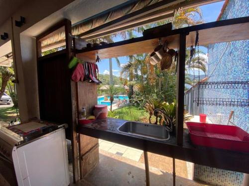 Rancho Lindas Aguas Carmo do Rio Claro في كارمو دو ريو كلارو: مطبخ مع حوض ونافذة كبيرة