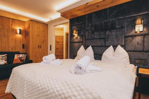 a bedroom with a large white bed with towels on it at Hotel Gasthof Mitteregger - BEST PLACE in town with summercard included in Kaprun