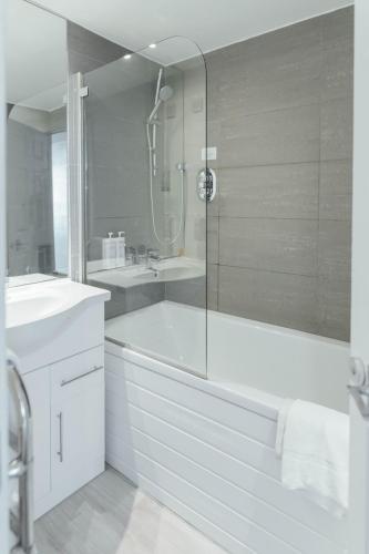 a bathroom with a shower and a tub and a sink at Queens Hotel & Spa in Brighton & Hove