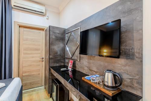 a room with a tv on a wall at La Pazza Suites in Istanbul