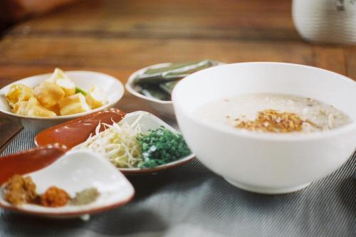 una ciotola di zuppa e ciotole di cibo su un tavolo di Homestay Yellow Natural House a Siem Reap