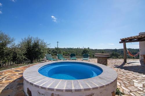 a circular pool with chairs and a swing at Casa Moinho Da Eira in Loulé