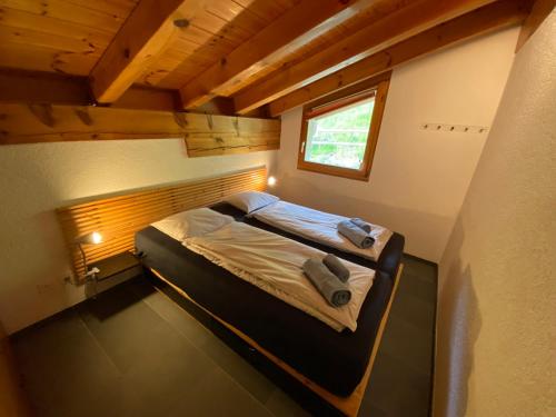a small bed in a small room with a window at Casa Ansiel - 2.5 Zimmer Ferienwohnung am Sonnenhang von Falera in Falera