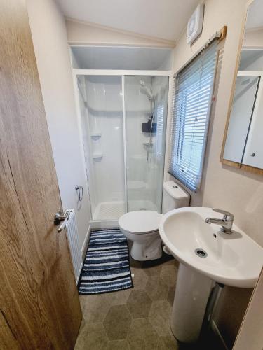 a bathroom with a shower and a toilet and a sink at Golden Palm Resort - The Adelaide - Coastal Caravan Breaks in Skegness