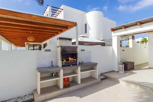 a fireplace on the side of a white house at Villa Bella Valen in Playa Blanca