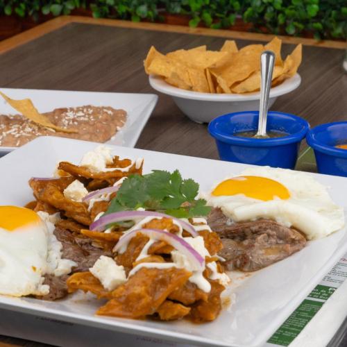 a plate of food with eggs and fries on a table at Hotel El Dorado in Tecate