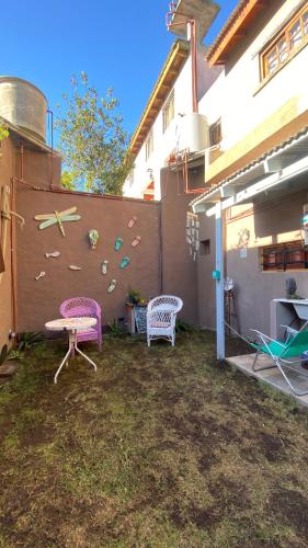 a backyard with two chairs and a fence with a climbing wall at Vientos de mar in Mar del Tuyú