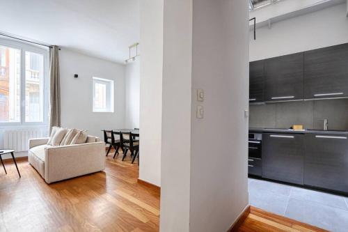 un salon avec un canapé et une cuisine dans l'établissement Concorde Saint Honore Apartment 1BR 4P, à Paris