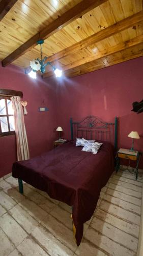 a bedroom with a large bed in a red wall at Vientos de mar in Mar del Tuyú