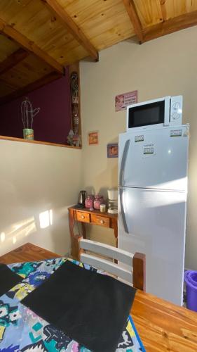 a kitchen with a refrigerator with a microwave on top of it at Vientos de mar in Mar del Tuyú