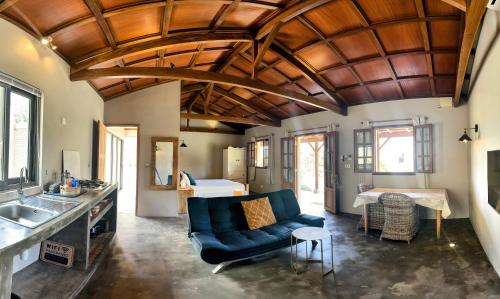 a living room with a blue couch and a table at Lakaz Kannell - Coconut Lodge secluded outside shower, infinity pool in Cap Malheureux