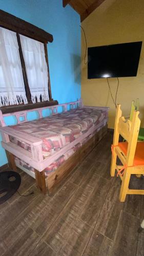 a bedroom with a wooden bed and a chair at Vientos de mar in Mar del Tuyú