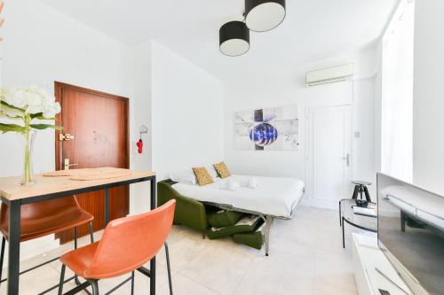 une chambre avec un lit, une table et des chaises dans l'établissement LE CONCORDIA Studio mignon avec une grande et belle terrasse, en plein cœur du centre-ville, à Cannes
