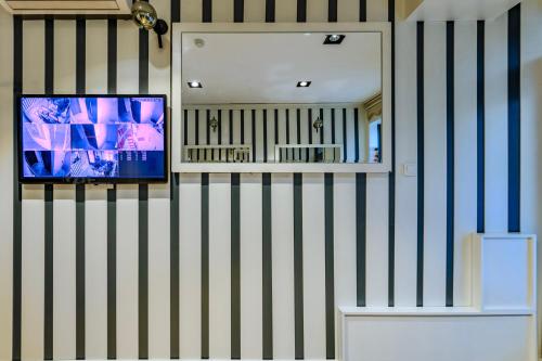 a room with a tv and a mirror on the wall at La Pazza Suites in Istanbul