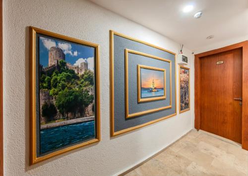 a hallway with three framed pictures on a wall at La Pazza Suites in Istanbul