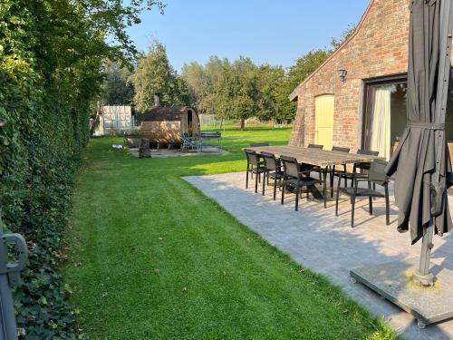a table and chairs in a yard next to a building at Wildenburgs klaverhuisje in Wingene