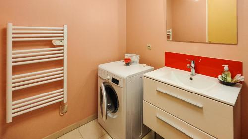 une petite salle de bains avec un lave-linge et un lavabo dans l'établissement Cosy'Appart - LE MARTEL, à Rouen