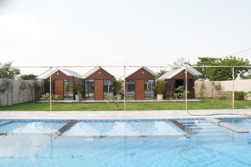 an empty swimming pool with houses in the background at Great Escape Club Indore in Indore