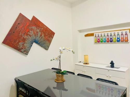une salle à manger avec une table, des chaises et des peintures murales dans l'établissement Maisonnette au calme proche T2, à La Garenne-Colombes