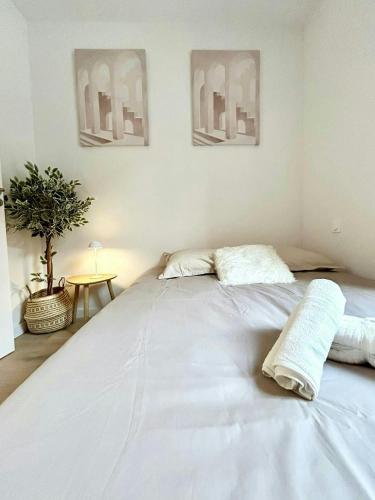 - un grand lit blanc dans une chambre avec 2 oreillers dans l'établissement Ô Berges Garonne, à Toulouse