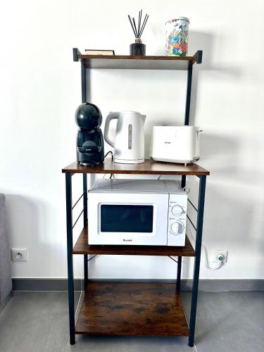 une étagère avec un four micro-ondes. dans l'établissement Charmant Appartement entre Paris et Disney, à Neuilly-sur-Marne