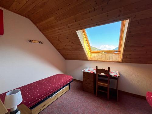 a small bedroom with a bed and a window at Appartement duplex pied des pistes et parking couvert in Arvieux