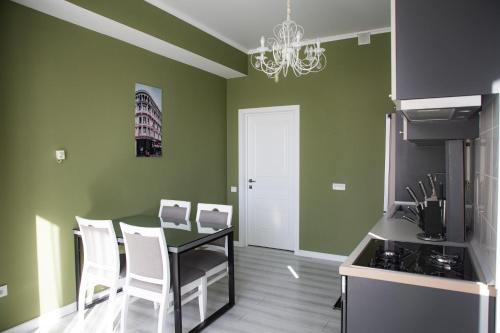 a dining room with green walls and a table and chairs at Casablanca Apart Hotel in Bishkek