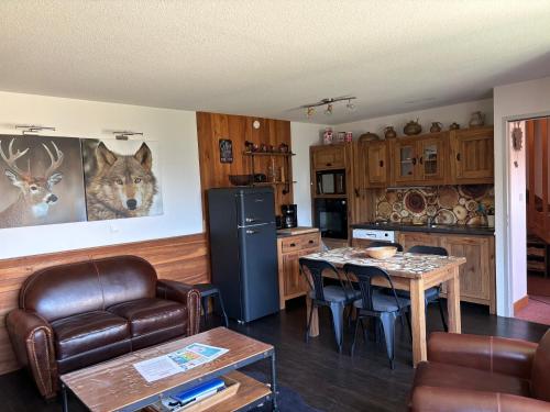 a kitchen with a table and a dining room at Appartement duplex pied des pistes et parking couvert in Arvieux