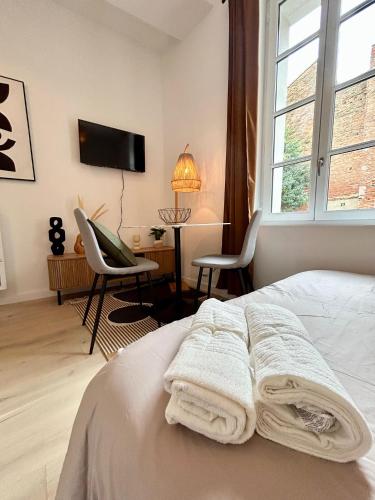 une chambre avec un lit avec des serviettes dessus dans l'établissement L'intime Saint Pierre - Paisible - Centre ville, à Toulouse