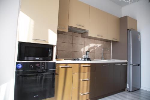 a kitchen with a black refrigerator and a microwave at Casablanca Apart Hotel in Bishkek