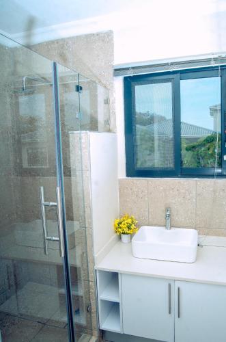 a bathroom with a sink and a shower at Estate Apartments in Lusaka