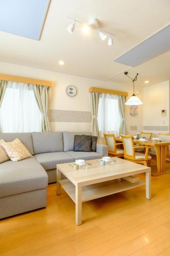 a living room with a couch and a table at Beyond Comfort 新宿大久保 - 最大10名でゆったり滞在 in Tokyo