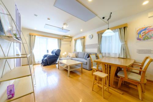 a living room with a table and a couch at Beyond Comfort 新宿大久保 - 最大10名でゆったり滞在 in Tokyo